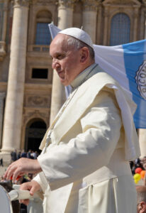 Papst Franziskus vor dem Petersdom in Rom mit vatikanischer Flagge im Hintergrund
